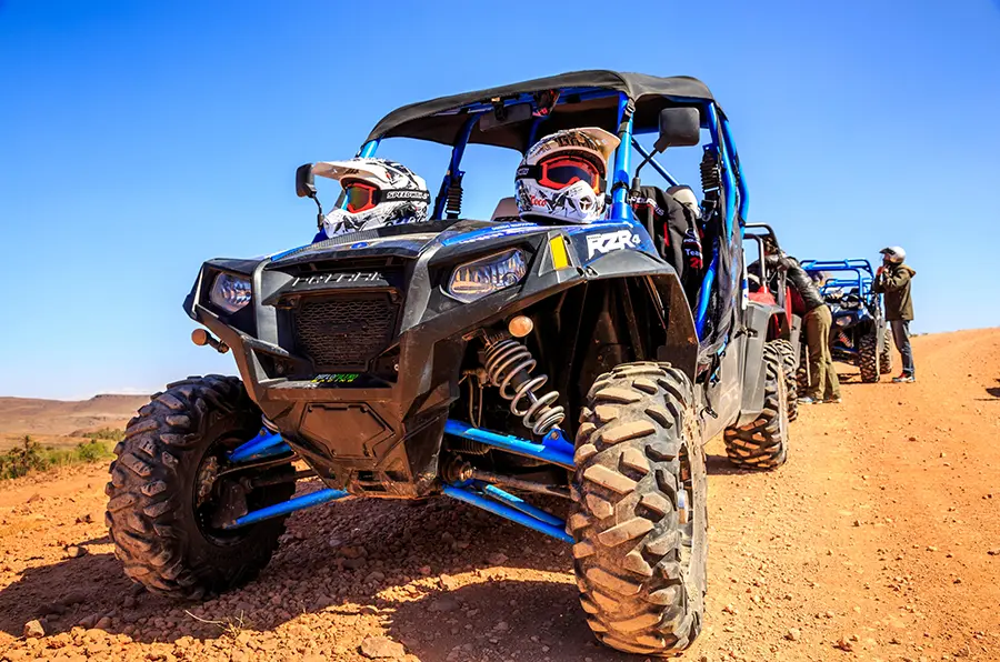 Buggy driving across Agafay desert under a clear blue sky