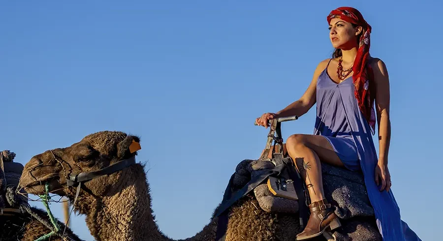 Confident woman riding a camel in the Agafay desert
