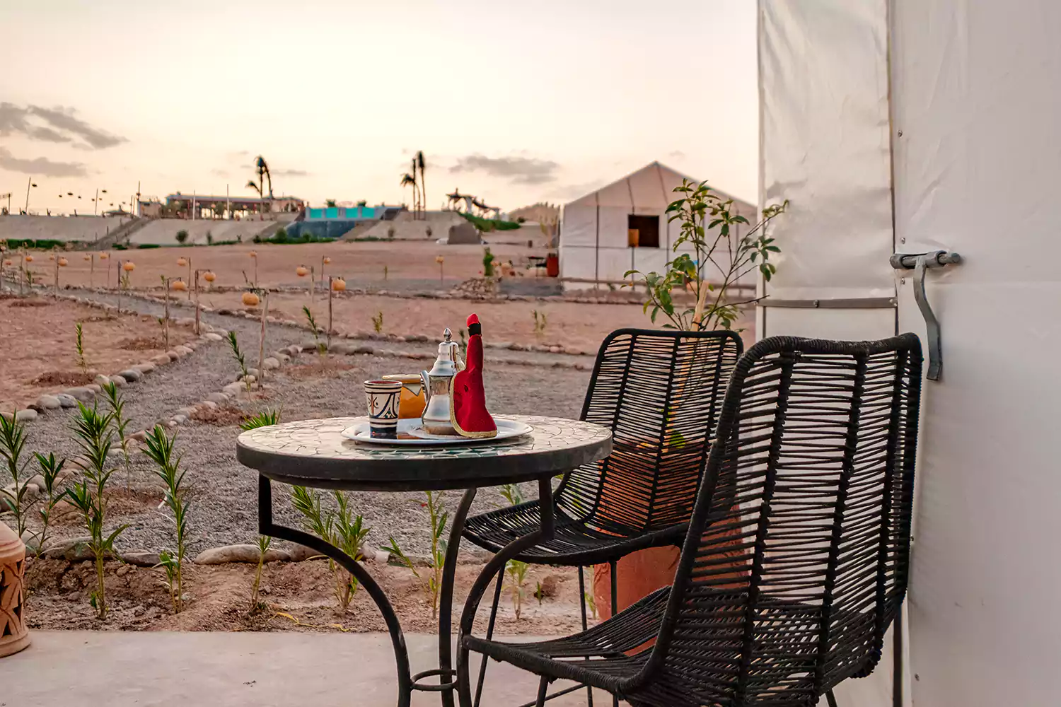 A calm and safe luxury camp setting in the Agafay Desert featuring traditional Moroccan tents and lounge areas
